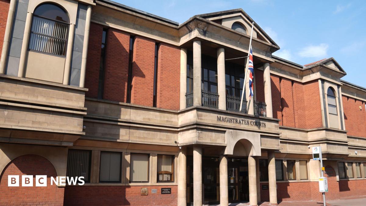 A view of Leicester Magistrates Court, a red brick building with beige stone features and a Union Jack outside