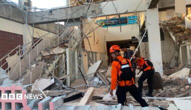Emergency workers look through the rubble at Lauren Say port in Maumere