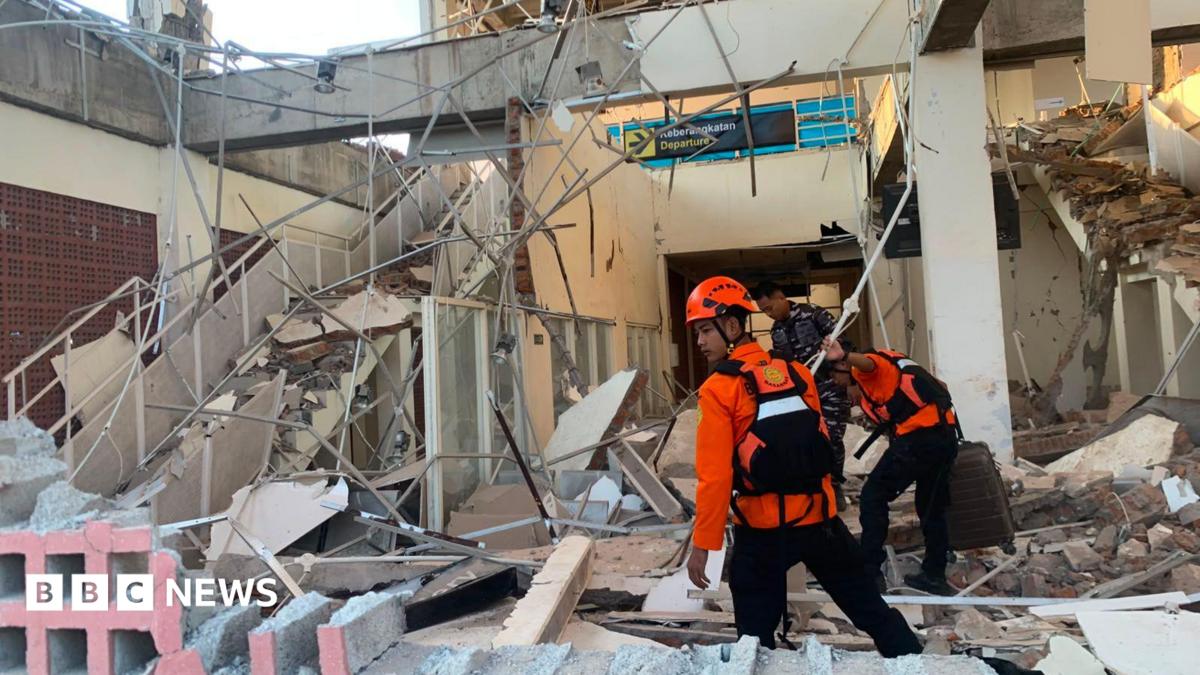Emergency workers look through the rubble at Lauren Say port in Maumere