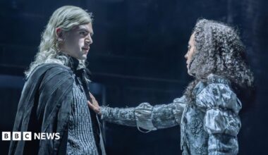 Noah Ritter (Prince Rhaegar Targaryen) and Harmony Rose-Bremner (Lyanna Stark) facing each other in costume in a scene from Game of Thrones: The Mad King. She has an arm outstretched with her palm on his chest