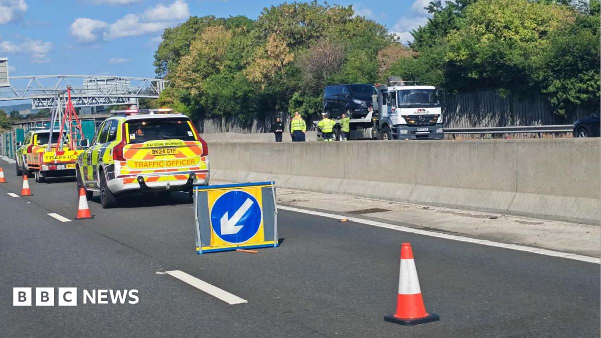 The scene of a fatal crash on the M20. There are two National Highways vehicles and a series of cones closing off the stretch of motorway. There is a tow truck on the other side of the motorway.