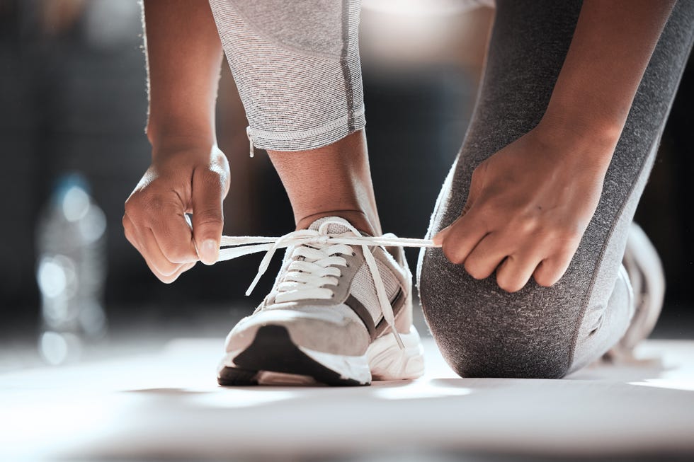 Cropped shot of an unrecognizable woman tying her shoelaces while exercising at the gym should come with a warning