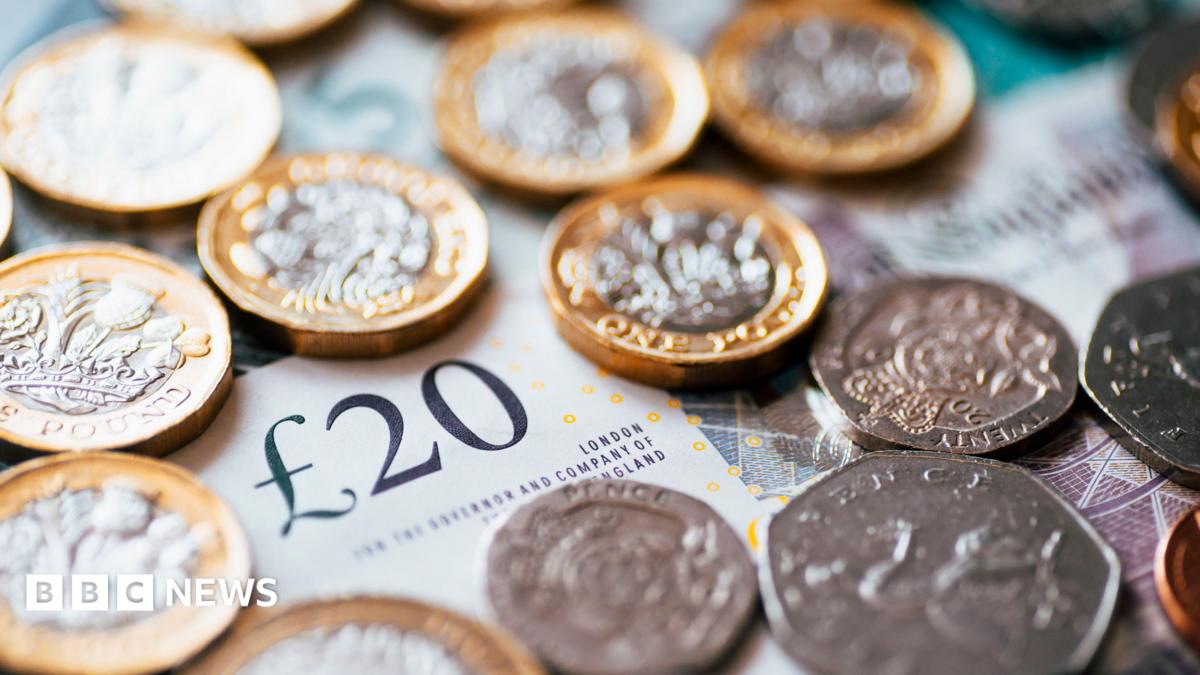 A stock image which is a close up of British cash with notes and coins. The picture includes a £20 note and a range of coins including £1 coins, 50ps and 20ps.
