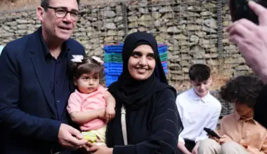 Britain’s Prime Minister Andy Burnham with a mother and child during a visit to a family centre in Sheffield, northern England, on July 31.
