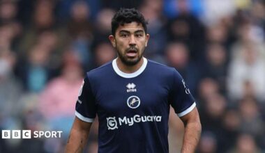 Massimo Luongo standing on the pitch wearing Millwall kit during a match in 2025
