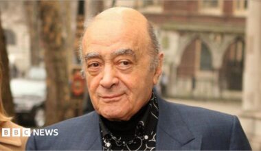 Harrods owner Mohamed Al Fayed wearing a suit and black shirt