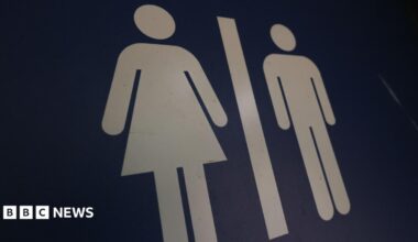 A blue gender neutral toilet sign, showing an image of a woman on the left and the image of a man on the right.
