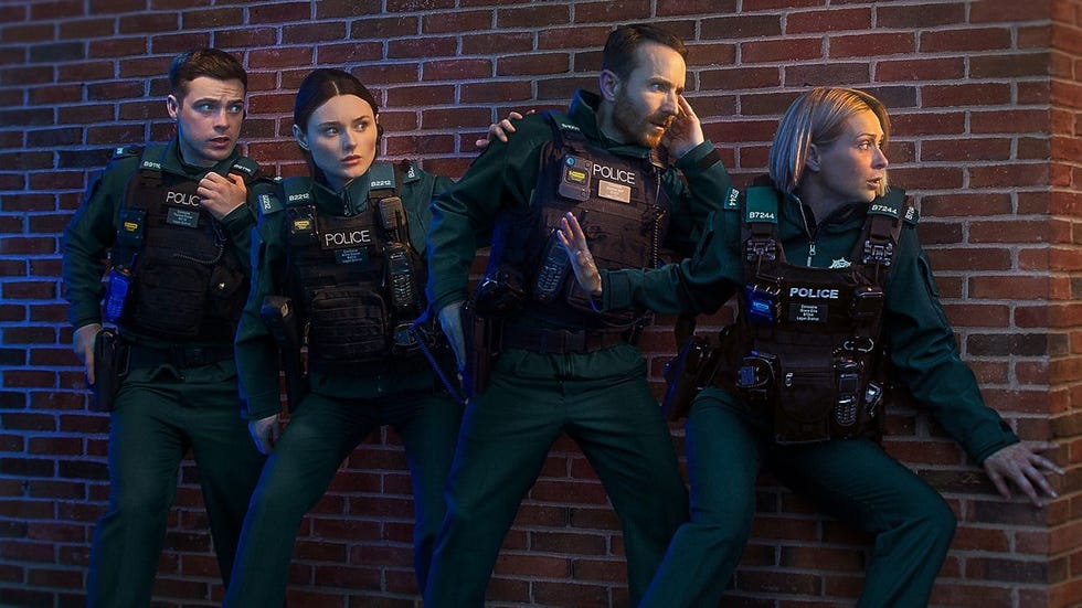 four police officers in tactical gear crouching against a brick wall. four police officers in tactical gear crouching against a brick wall.
