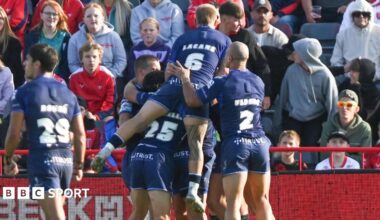 Toulouse players in blue kits jump on Mathieu Jussaume in celebration after he scored their first try in their win over Hull KR