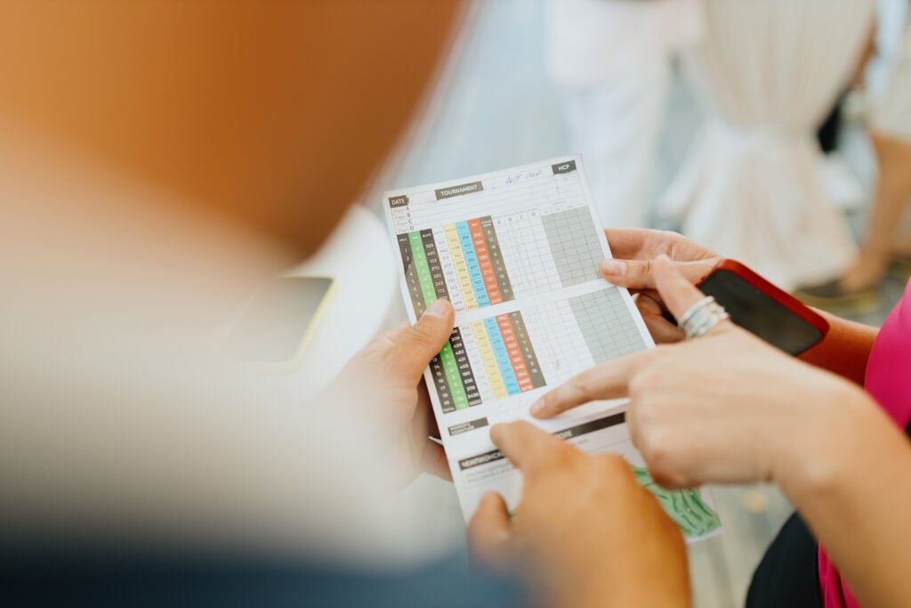 A golfer marks a score on a golf scorecard | Source: Adobe Stock odds of beating your handicap
