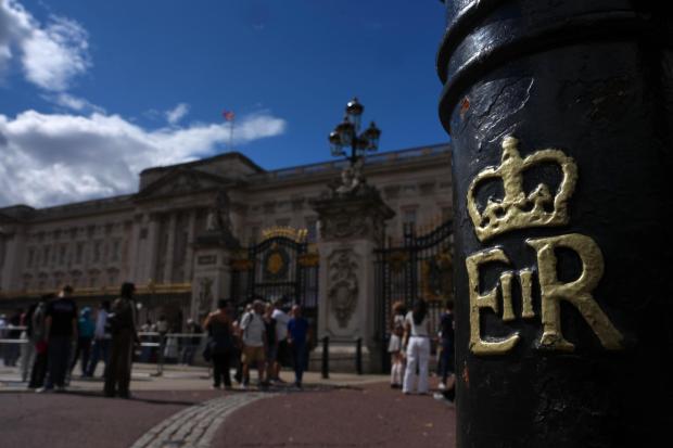Tourists walk at Buckingham Palace in London, Thursday, Aug. 20, 2026. (AP Photo/Kin Cheung)