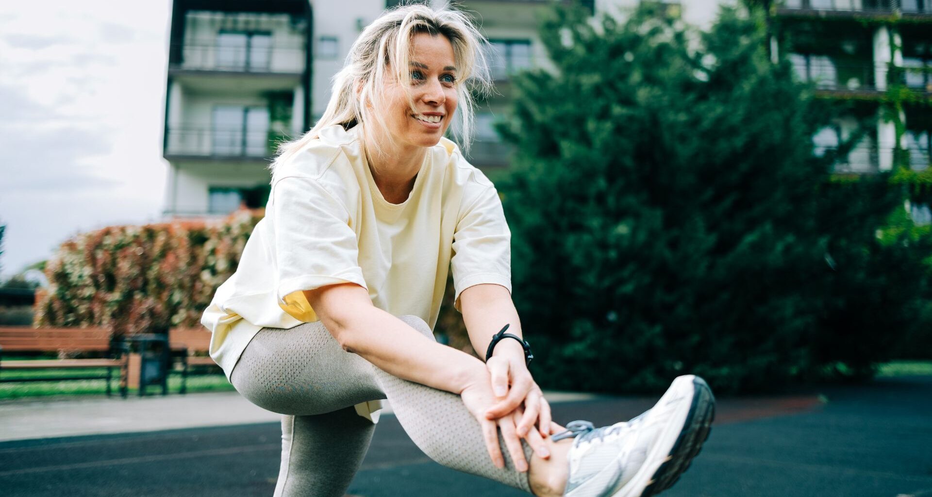 Woman setting up to do lateral leg raises outside