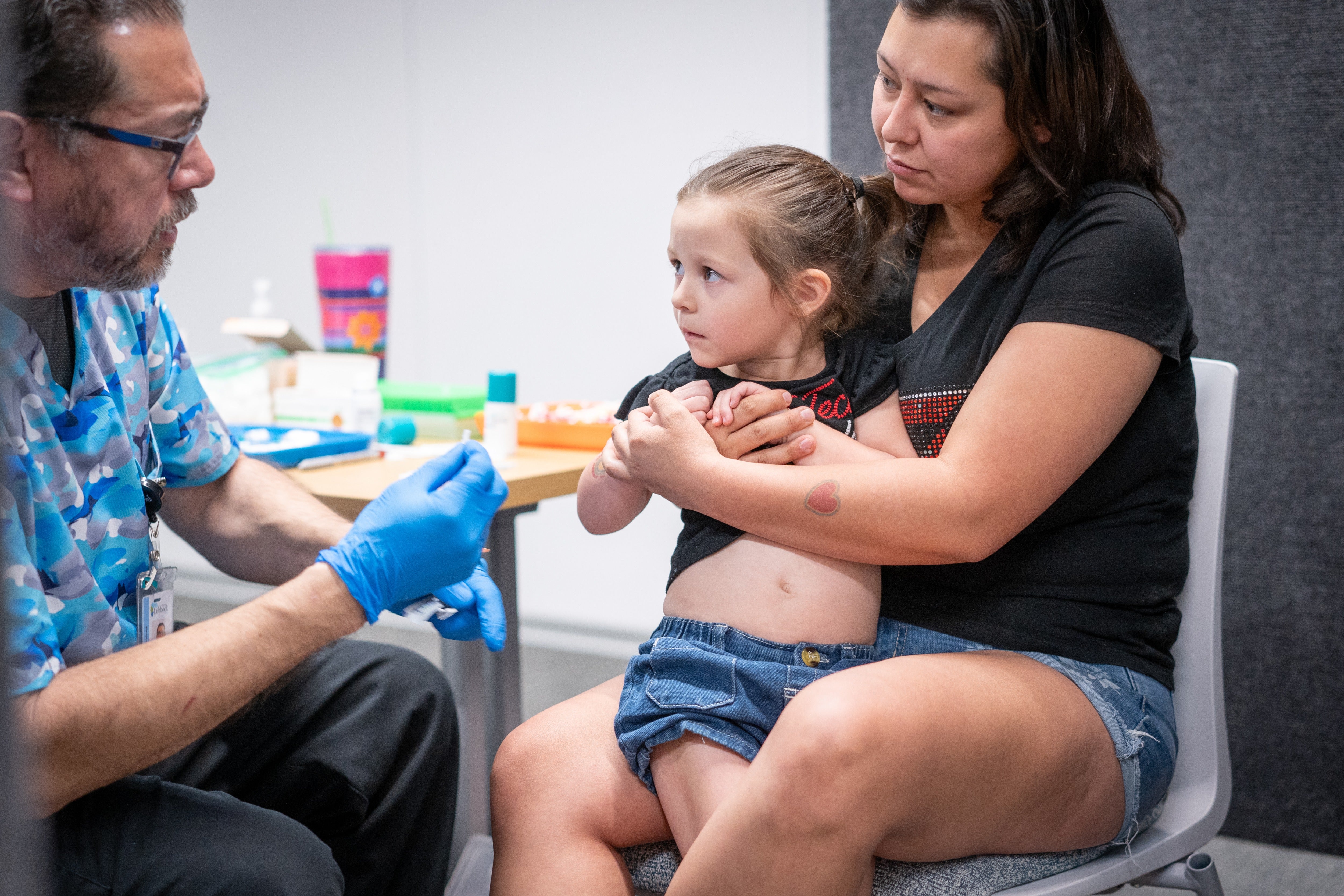 A woman holds her young daughter while she gets the MMR vaccine at a clinic in Lubbock, Texas, last year. Kennedy said parents should give their children the shots on CNN this weekend
