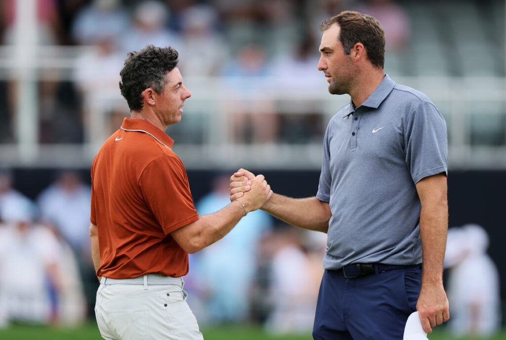 Rory McIlroy of Northern Ireland, left, shakes hands with Scottie Scheffler of the United States on the 18th hole green after finishing the second round of the PGA Championship at Quail Hollow Country Club