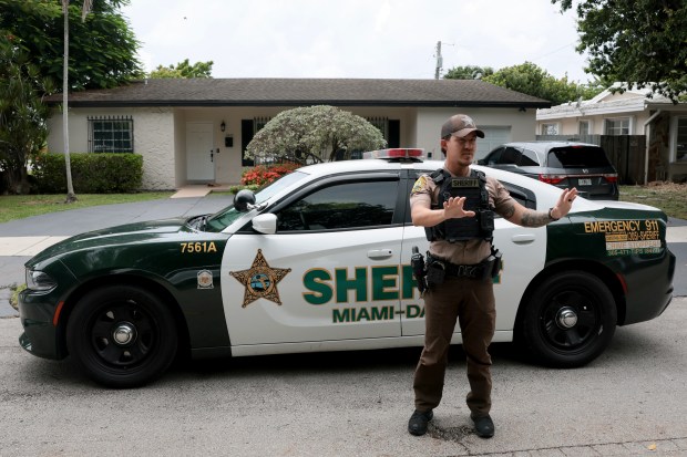 A Miami-Dade County Sheriff's deputy asks the media to step back as he visits the home where Perez Hilton was found after he appeared to harm himself during a TikTok livestream on Aug. 5, 2026, in Westchester, Florida. (Photo by Joe Raedle/Getty Images)