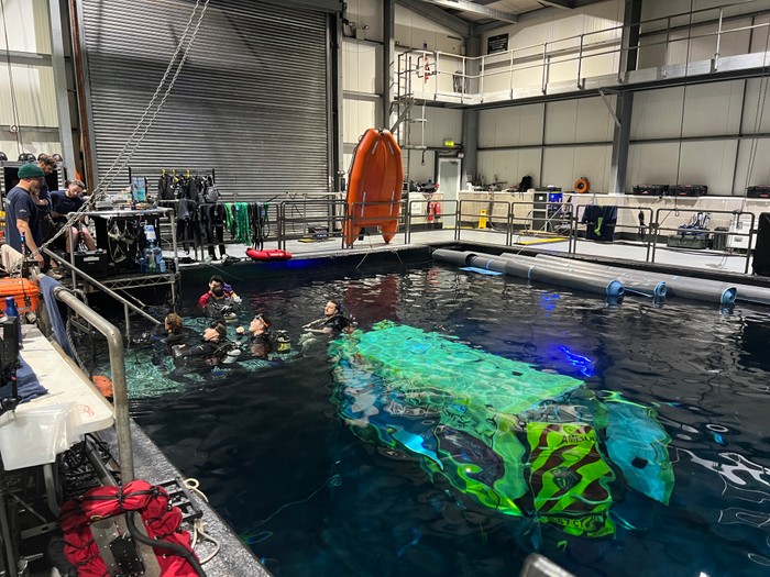 Divers surround an ambulance under the water of a tank at Pinewood Studios for Casualty's 40th anniversary
