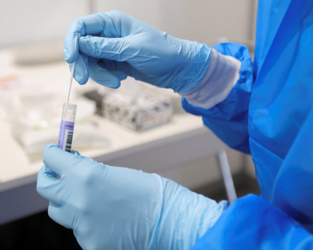 A medical worker stores a swab in a vial at XL Schiphol test location, after Dutch health authorities said that 61 people who arrived in Amsterdam on flights from South Africa tested positive for COVID-19, in Amsterdam, Netherlands, November 27, 2021. REUTERS/Eva Plevier