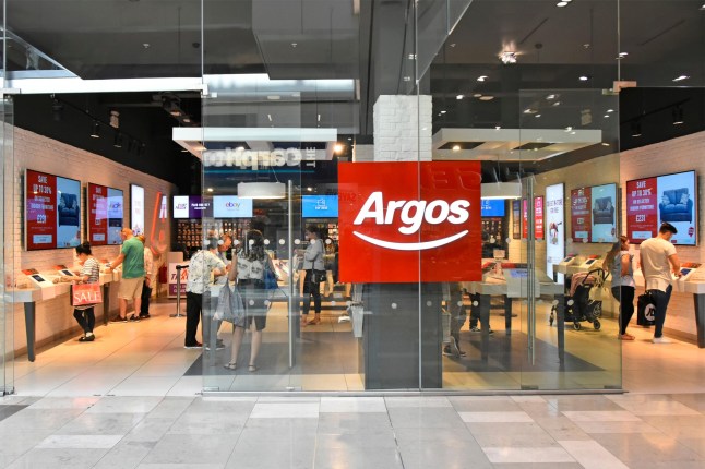 RG973Y Shoppers behind glass building shop front window at Argos catalogue shopping store in Westfield mall in Stratford City Newham East London England UK