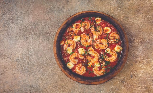 saganaki with shrimp, in a clay pan, Greek dish, shrimp in tomato sauce, feta cheese, homemade, no people,