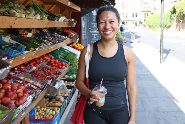 Lawyer Jennifer Cadet standing outside a shop holding a cold drink.