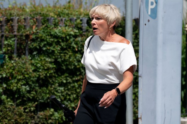 Nicola standing in Walford looking shocked in EastEnders