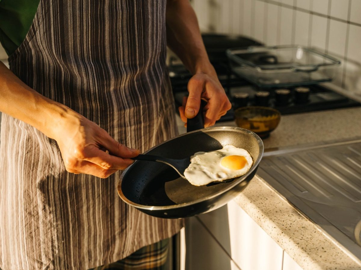 Young man cooking in light kitchen at home.