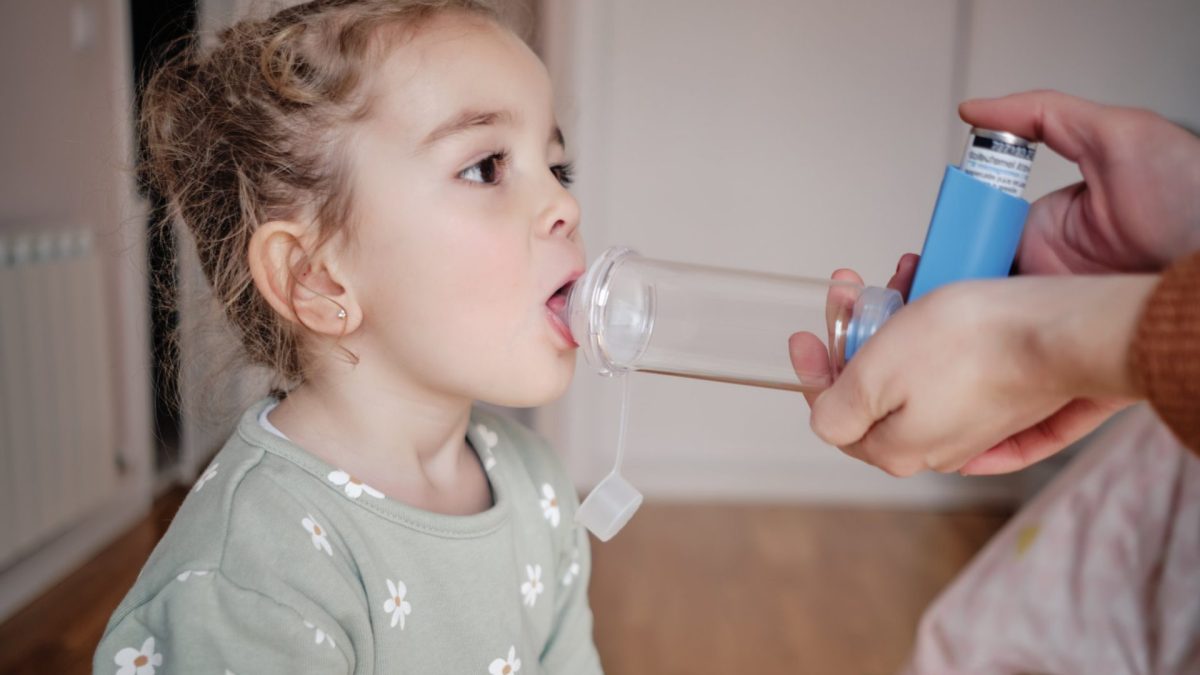 Young girl receiving respiratory treatment at home