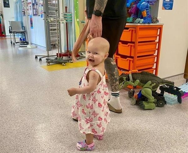 Florence Wilde, in hospital with her father Dom. // A toddler whose belly ballooned was diagnosed with a 2kg tumour after doctors repeatedly told her parents she was constipated. Florence Wilde, two, was diagnosed with neuroblastoma - a rare cancer of the cell - in November 2024. Her parents Anna Chattaway and Dom Wilde, both 32, first noticed something was wrong when Florence became repeatedly rundown. The toddler's tummy began to swell so the pair rushed her to Three Villages GP in Stourbridge but doctors ruled out the symptoms as constipation, prescribing the tot laxatives. Photo released 21/08/2026