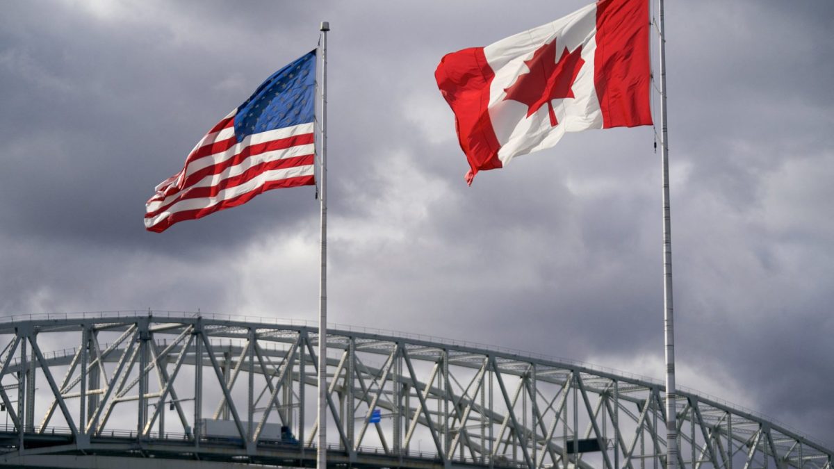 TOPSHOT - (FILES) The US and Canadian flags flutter next to the Blue Water Bridge border crossing in Point Edward, Ontario, on October 24, 2025. Canadian Prime Minister Mark Carney said on August 22, 2026 he would slap retaliatory tariffs on the United States after walking away from a 
