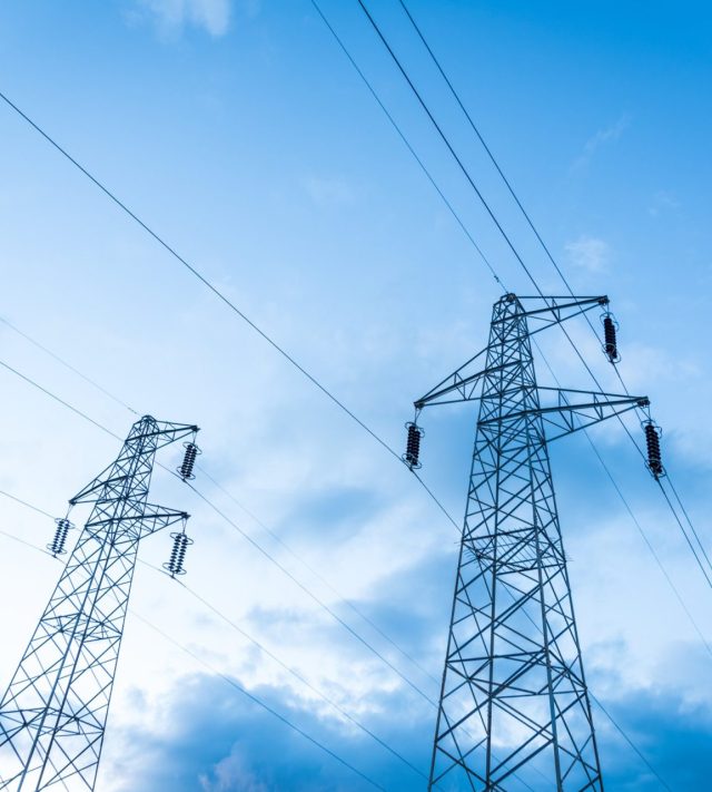 Sun setting behind a row of electricity pylons