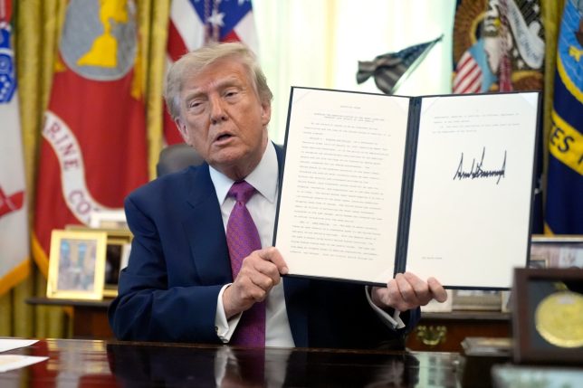President Donald Trump holds up a signed executive order in the Oval Office of the White House, Thursday, Aug. 27, 2026, in Washington. (AP Photo/Manuel Balce Ceneta)