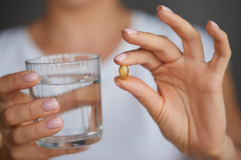 Woman Taking Vitamin D Omega 3 Supplement Pill