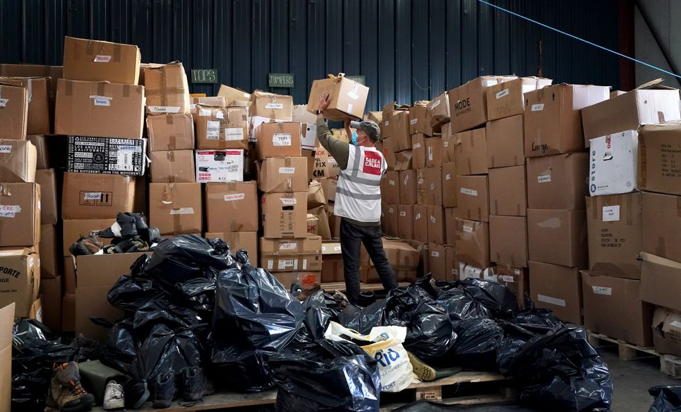 A Care4Calais worker stacks up boxes of freebies ready to hand to would-be migrants in France