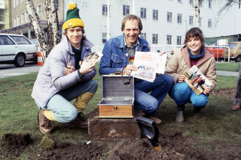 Three people burying a time capsule