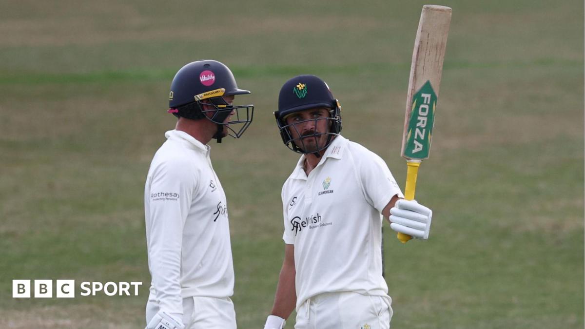 Glamorgan batter Kiran Carlson raises his bat stood next to Colin Ingram having scored 50 against Leicestershire