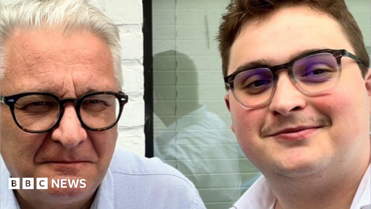 A close-up of two men both wearing glasses