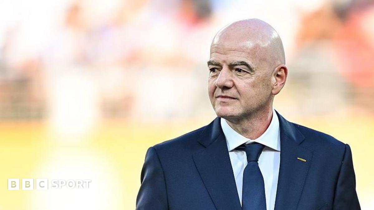 Gianni Infantino, wearing a dark suit and tie, looks to his right