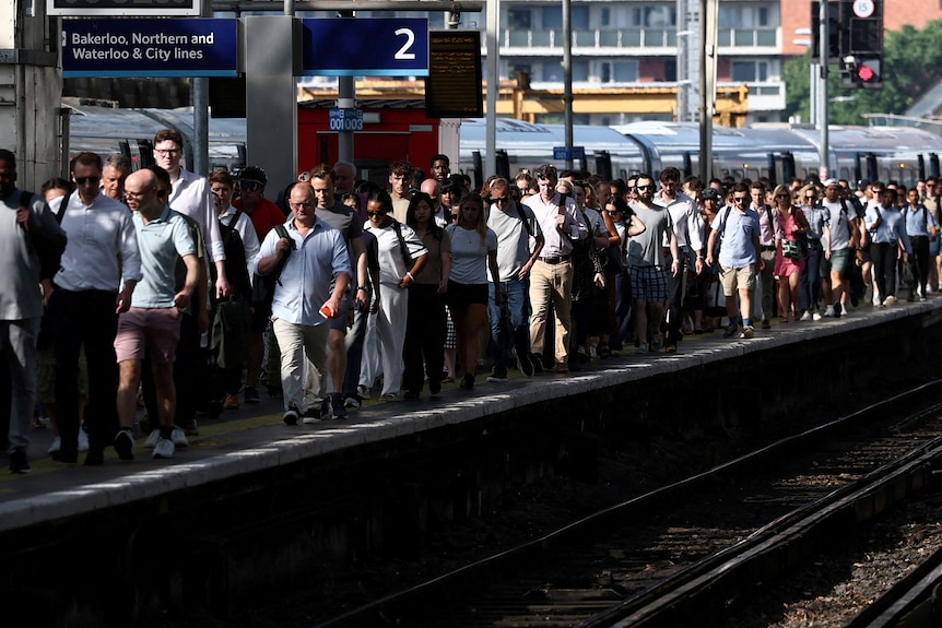 Rail passengers crowd a platform.