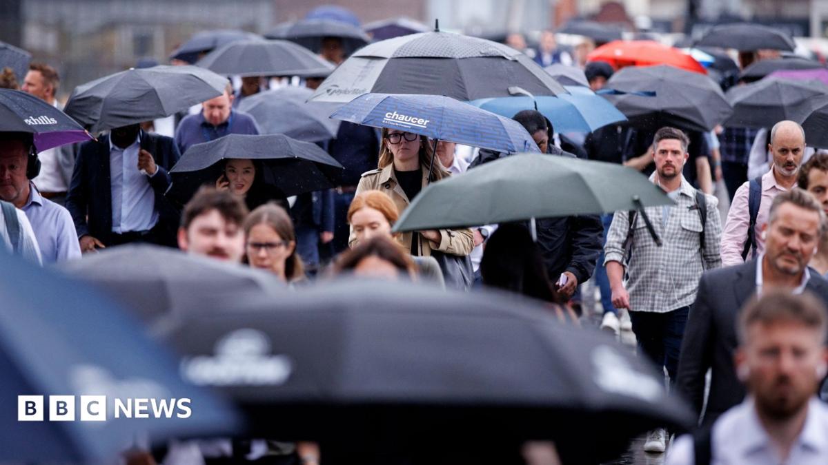 A busy scene of people walking in the rain with umbrellas up.