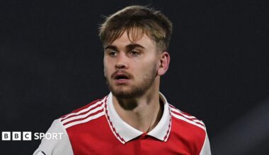 Billy Vigar looking on in a red Arsenal kit