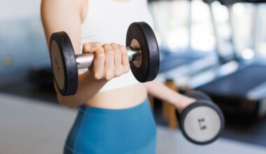 Woman training with dumbbells at a gym.