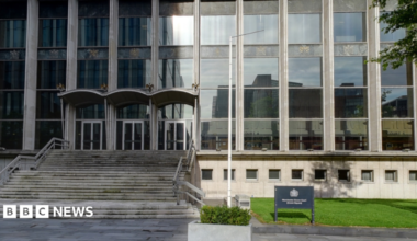 Manchester Crown court. A grey building with rows of steps leading to the entrance.