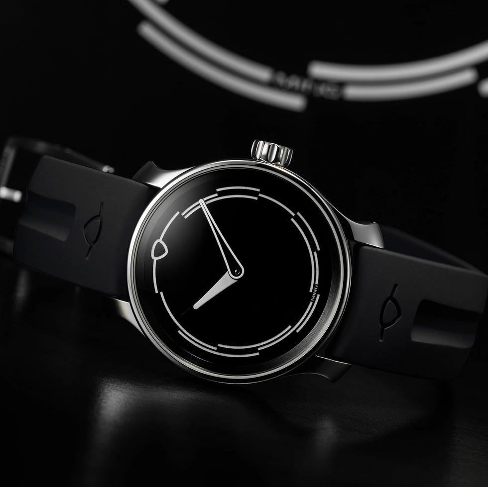 A minimalist black wristwatch with a distinctive round dial and sleek rubber strap. A minimalist black wristwatch with a distinctive round dial and sleek rubber strap.