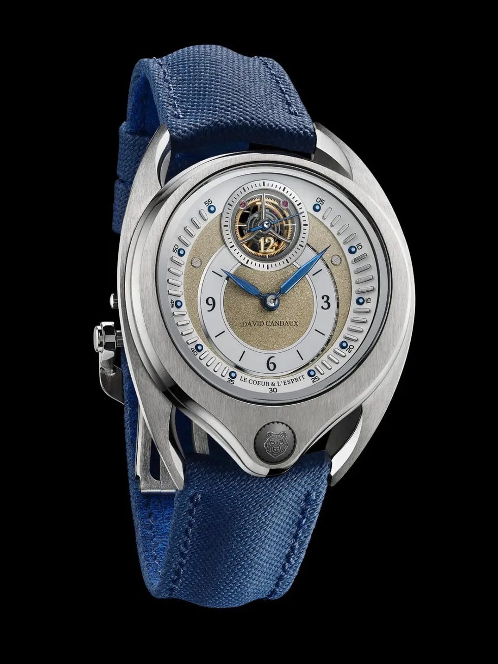 A luxury watch with a blue fabric strap and a distinctive dial featuring a tourbillon and elegant design elements. A luxury watch with a blue fabric strap and a distinctive dial featuring a tourbillon and elegant design elements.