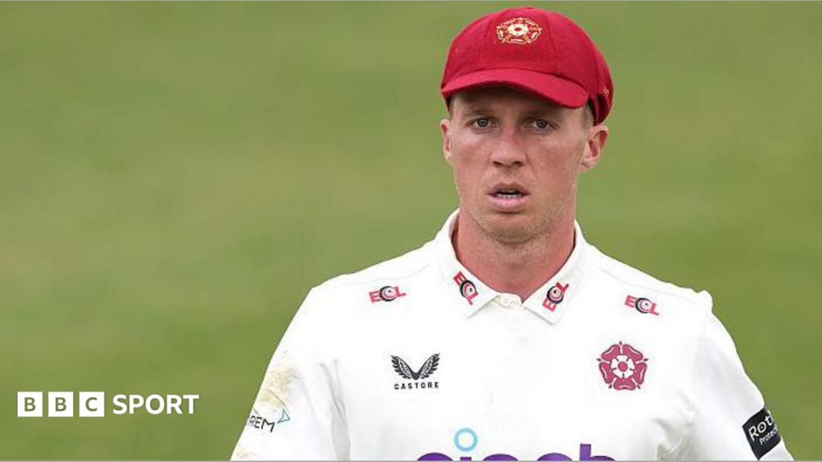 Nathan McSweeney in a white Northamptonshire shirt and claret baseball cap during a match