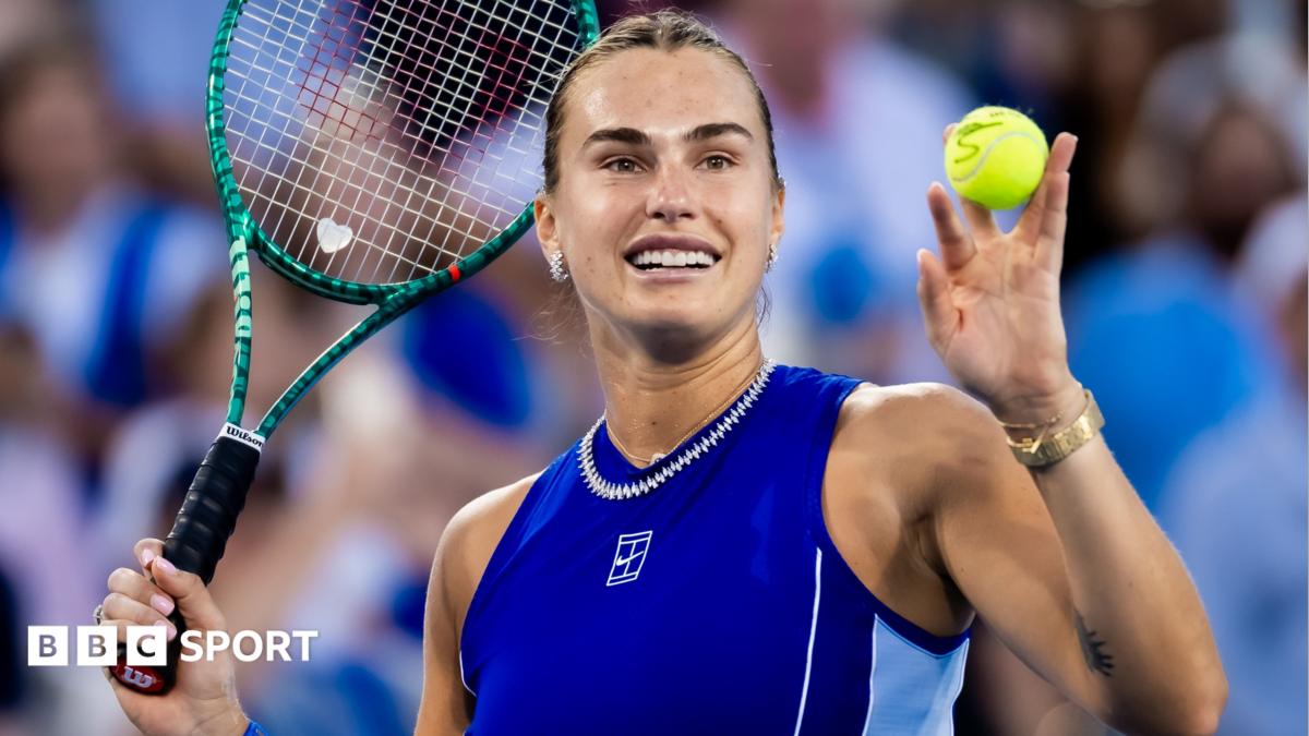Aryna Sabalenka holds up a ball and her tennis racquet after beating Wang Xinyu at the Cincinnati Open