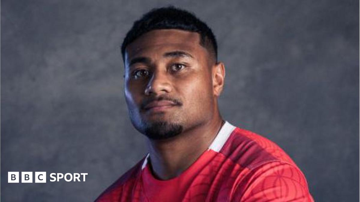 A portrait photo of Sam Moli in a red Tonga rugby jersey.