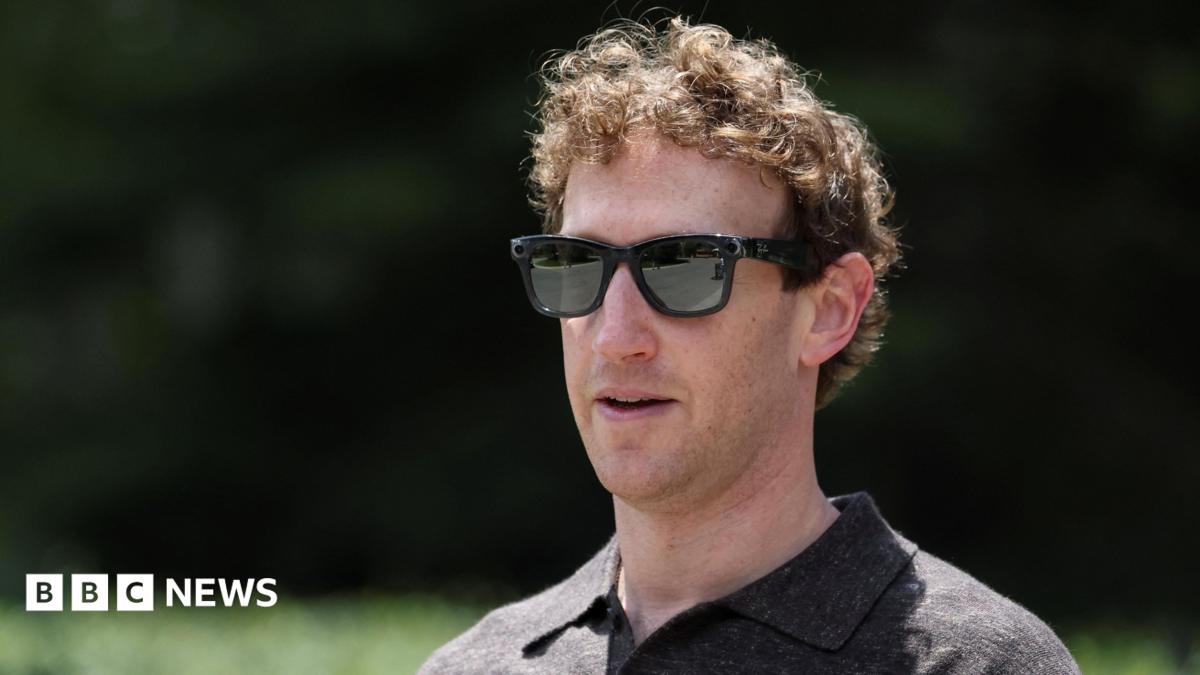 A close-up of Mark Zuckerberg, wearing a set of Meta Ray-Bans and brown top, walking through a park.