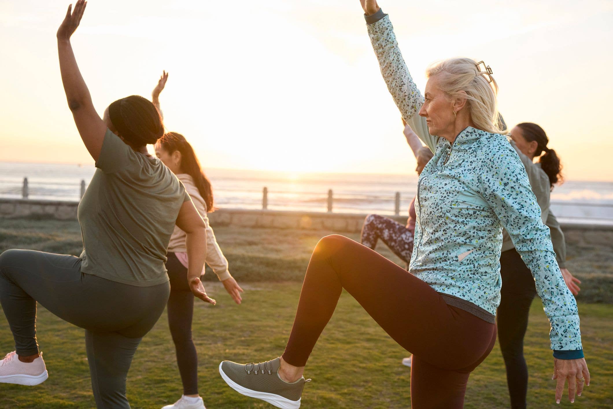 Side view of mature woman doing stretching exercise. Active females are doing their morning routine. She is wearing sports clothing.