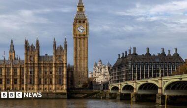 The Elizabeth Tower, known as Big Ben, and the Palace of Westminster beside the River Thames, with Westminster Bridge in the foreground under cloudy skies.
